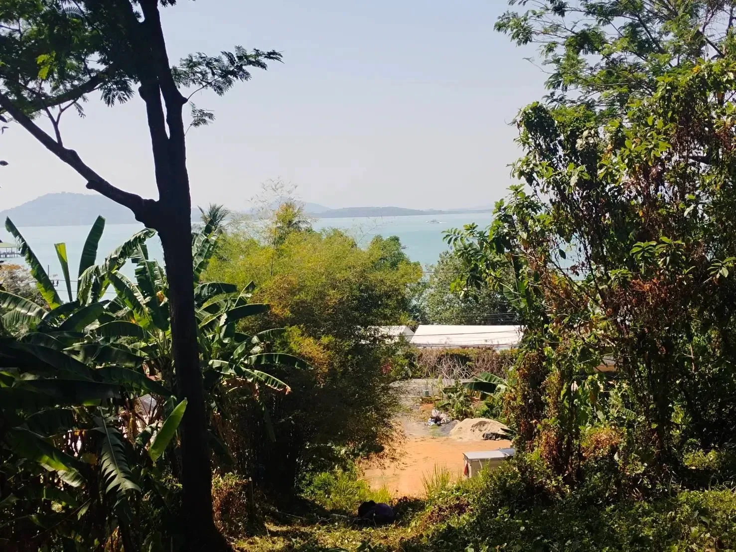 The plot slopes down to the paved road, with the sea and islands beyond, Cape Yamu